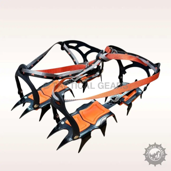 Pair of black and orange tooth ice climbing crampons with straps for ice climbing enthusiasts