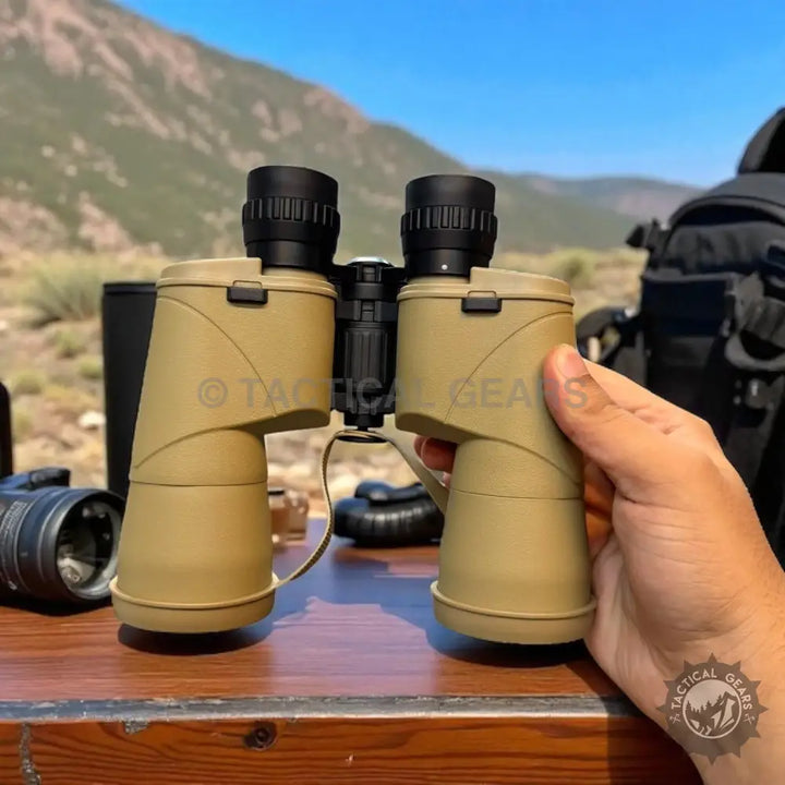 Tan-colored binoculars with black eyepieces and a central focusing wheel featuring green lens