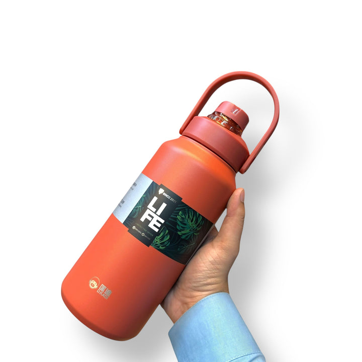 Coral orange 1300ml thermal hot vacuum bottle with handle held by person