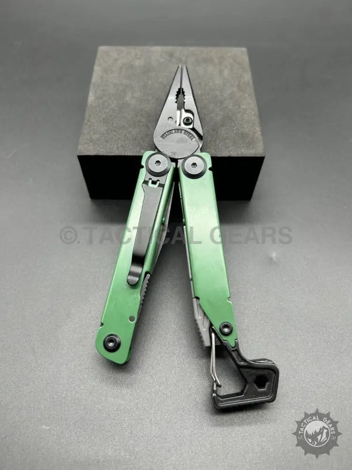 Open green stainless steel multi-tool pliers with black pocket clip and carabiner attachment