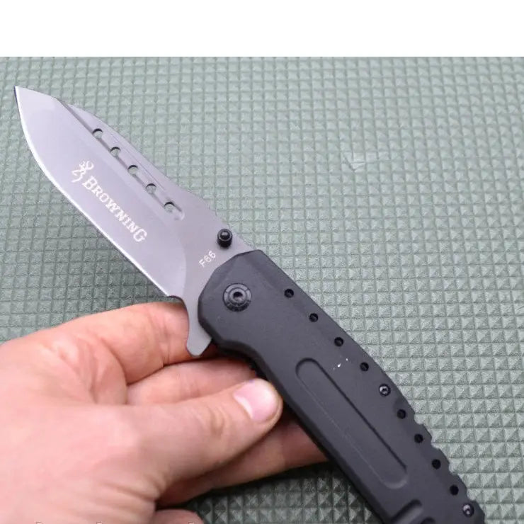 Person holding Browning F66 Survival Knife with gray folding blade and black handle