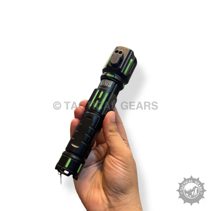 Black tactical emergency flashlight with green accents and glass breaker tip, 1km range