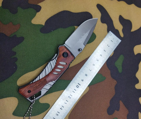 Buck USA X61 tactical folding knife with wooden handle and metal ruler display