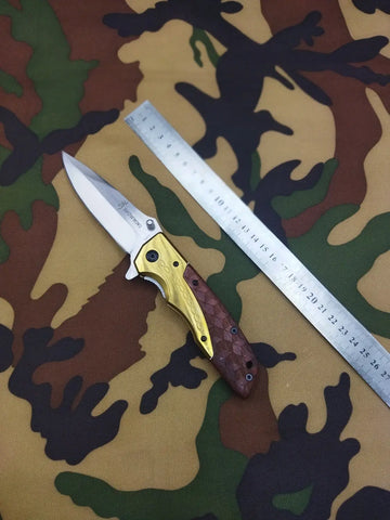 Folding pocket knife with gold and brown handle, Browning DA77 Titanium Wood Handle