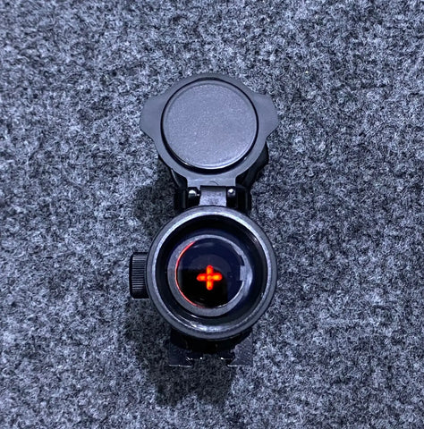 Black 1x40 Red Dot Sight with open lens cap and glowing red reticle for precision shooting