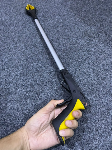 Black and yellow extended objects grabber tool with long handle and gripping claw