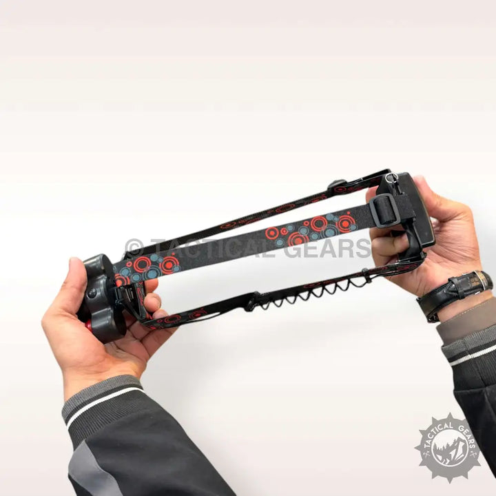 Black and red patterned adjustable rechargeable headlight held by two hands