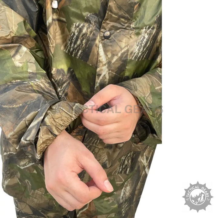 Person wearing a camouflage rain suit with elastic cuffs, ideal for outdoor rain protection
