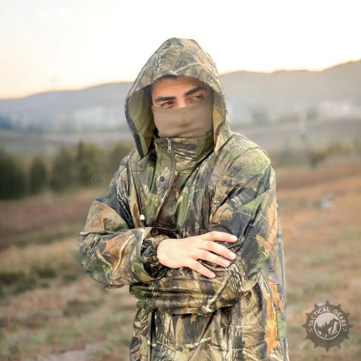 Person wearing hooded camouflage rain suit with face covering for all-purpose camo rain protection