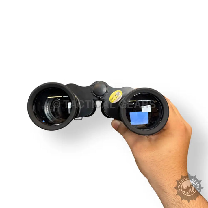 Black handheld Baigish 20x50 28mm binoculars with yellow sticker on right barrel