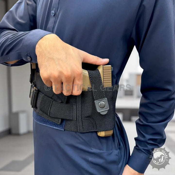 Person wearing blue shirt with belly band holster and magazine pouches for concealed carry
