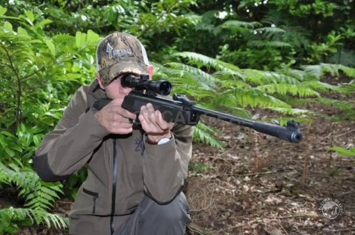 Person aiming LB-600 Air Rifle 5.5mm with factory set trigger blade in wooded area