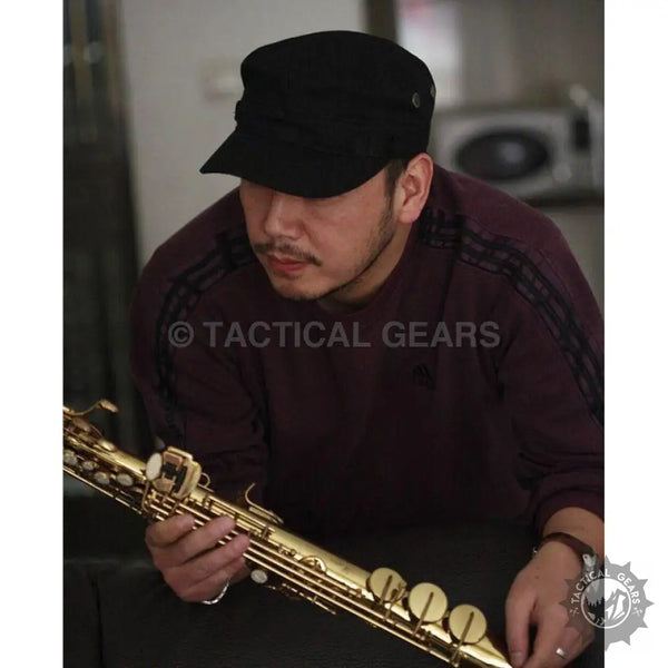 Man holding golden saxophone wearing jeep military hat and dark red military shirt