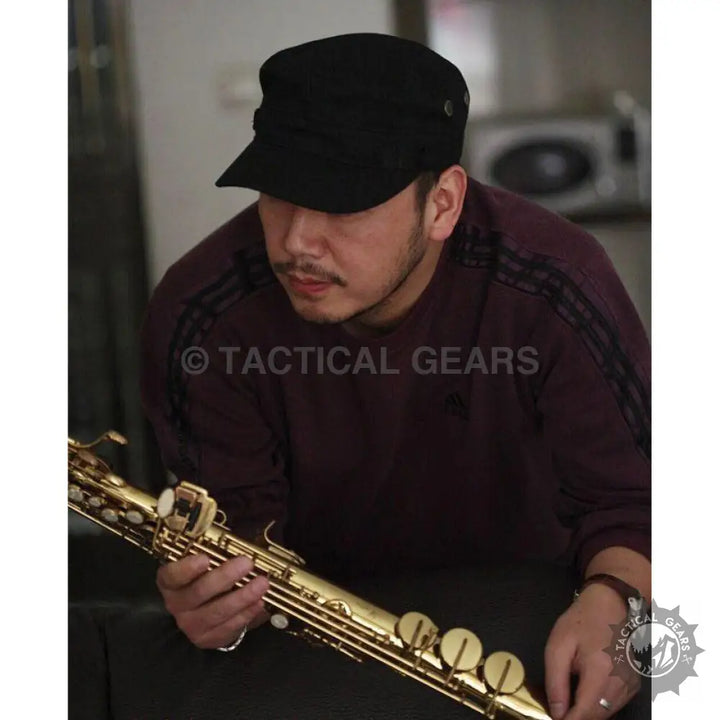 Man holding golden saxophone wearing jeep military hat and dark red military shirt