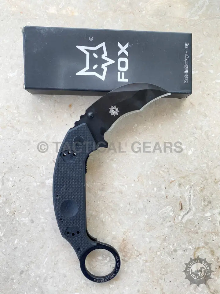 Black folding karambit knife with textured handle and finger ring by Fox Knives