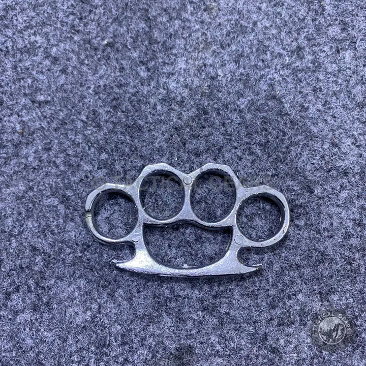 Silver-colored metal heavy steel knuckles with four finger holes and curved palm rest