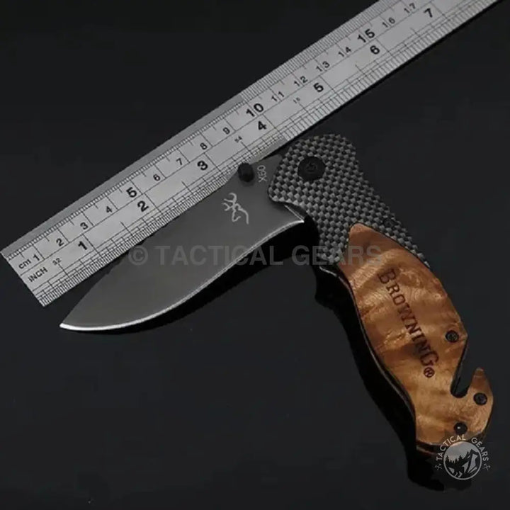 Browning X50 folding knife with dark blade, carbon fiber top handle, and gut hook