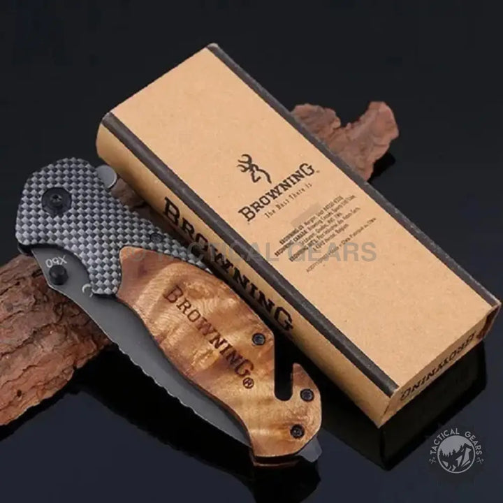 Browning X50 folding knife with patterned metal, wood handle, and partially serrated blade