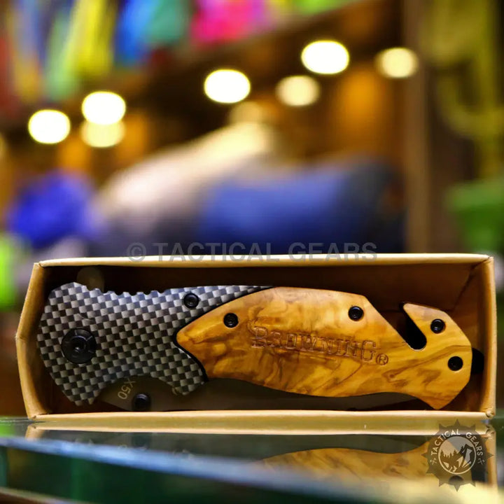 Browning X50 folding knife with two-tone handle, seatbelt cutter, and carbon fiber pattern