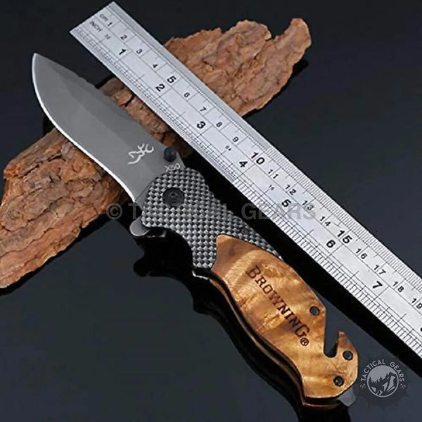 Browning X50 folding knife with gray blade, black carbon fiber handle, and wooden gut hook