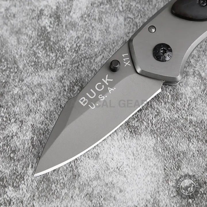 Gray Buck X11 Folding Knife with partially serrated blade and thumb stud measures durability