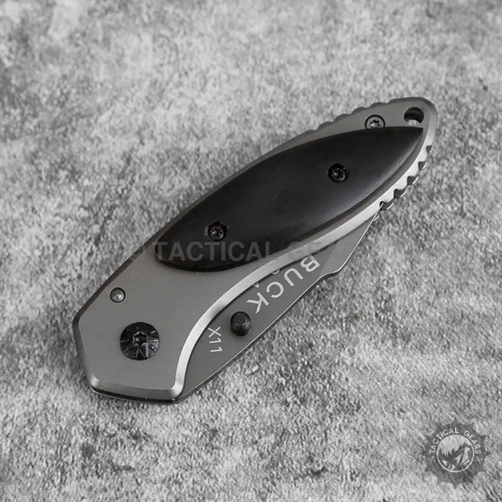 Buck X11 Folding Knife with gray and black blade and partial serration measures durability