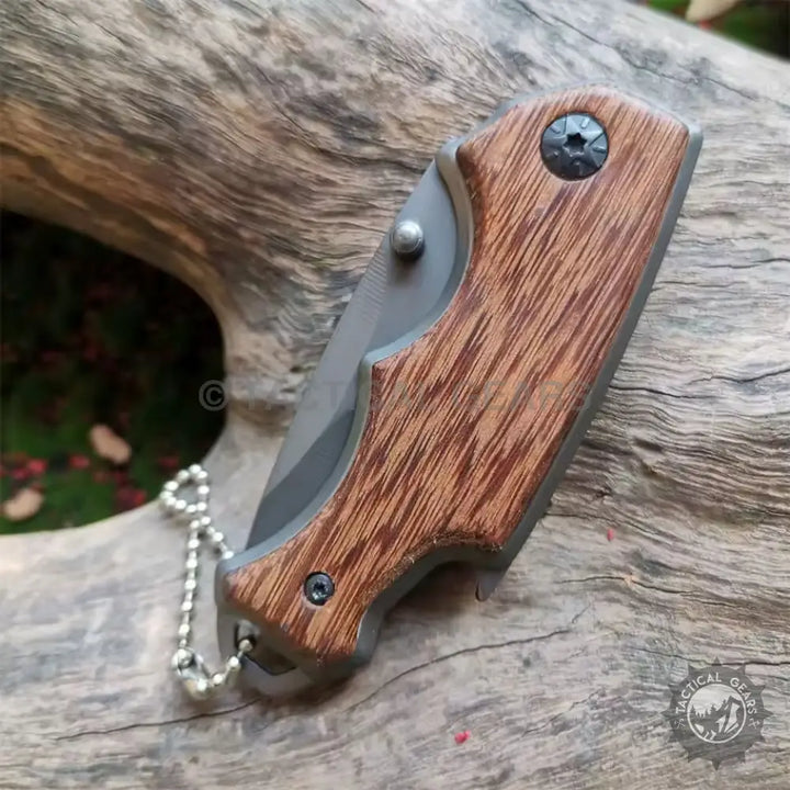Buck X74 folding pocket knife with wood-grain handle and keychain attachment