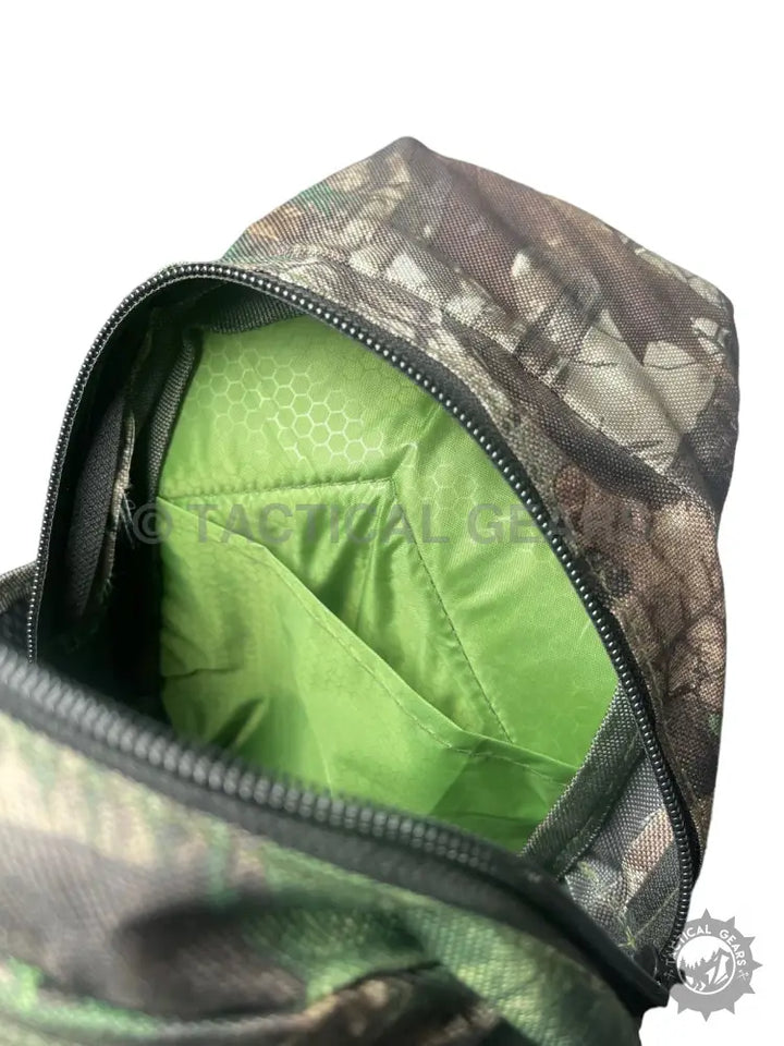Open camo hunting sling bag with bright green interior lining and internal pocket