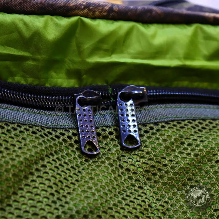 Green mesh camouflage mega duffle with black zipper and metallic pulls, perfect hunting bag