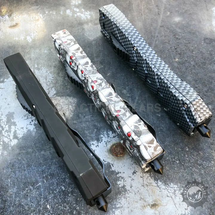 Combat OTF knives with glass breakers, black, skull pattern, and carbon fiber designs