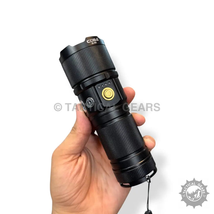 Black ribbed Coba Powerful Handheld Flashlight with gold power button and wrist strap