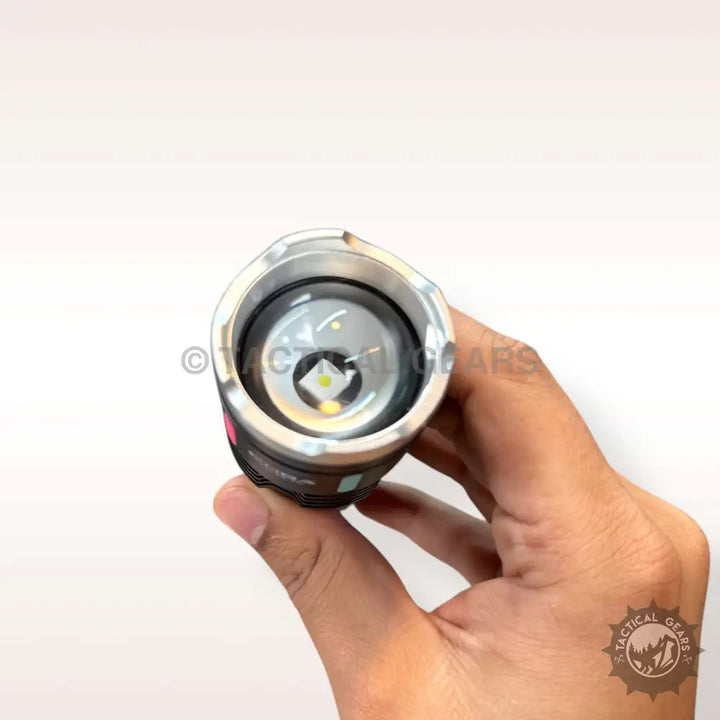Person holding COBA USB Charging Flashlight with illuminated LED and black silver design
