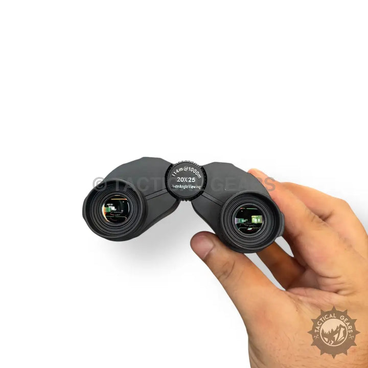 Black compact binoculars held in hand 20x25 mini binocular with carrying case