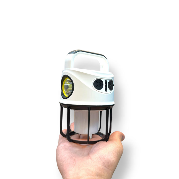 White dual light camping lantern with spotlight and handle held in hand for outdoor use