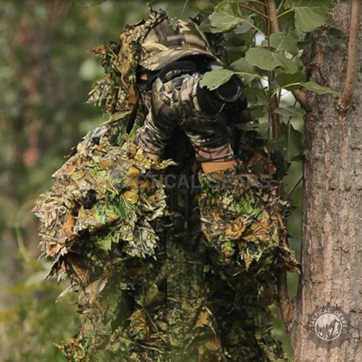 Person in leafy camouflage hooded jungle outfit with camera for easy concealment