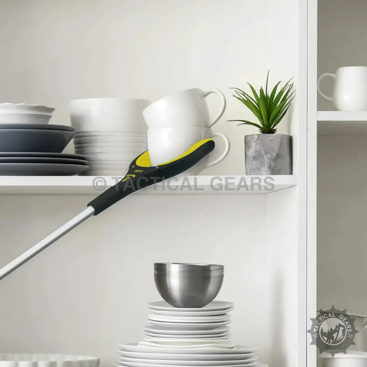 Extended objects grabber tool with yellow and black grip holding a white mug for easy reach