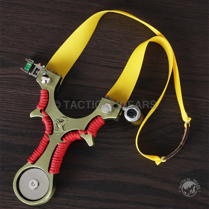 Green metal slingshot with red cord wrapping and yellow elastic bands, width for precision