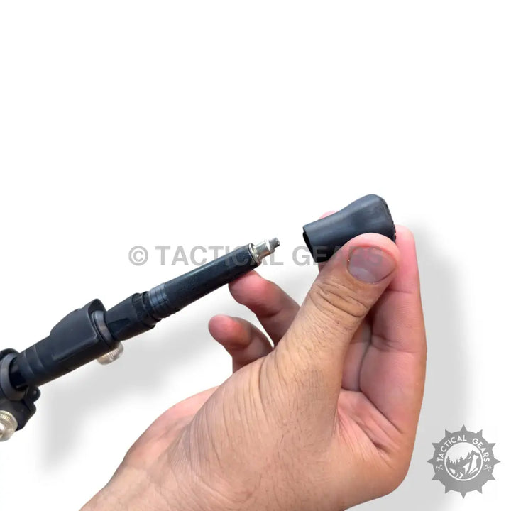 Hand holding a black folding hiking stick with adjustable height and removable rubber tip