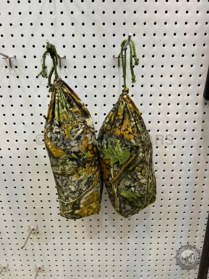 Camouflage drawstring bags hanging on a pegboard for 5 x 15 ground blind storage