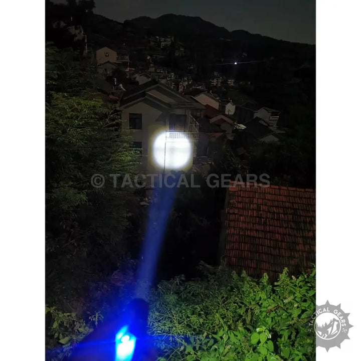 GT10 Outdoor Camping Flashlight illuminating a distant house with a blue beam at night