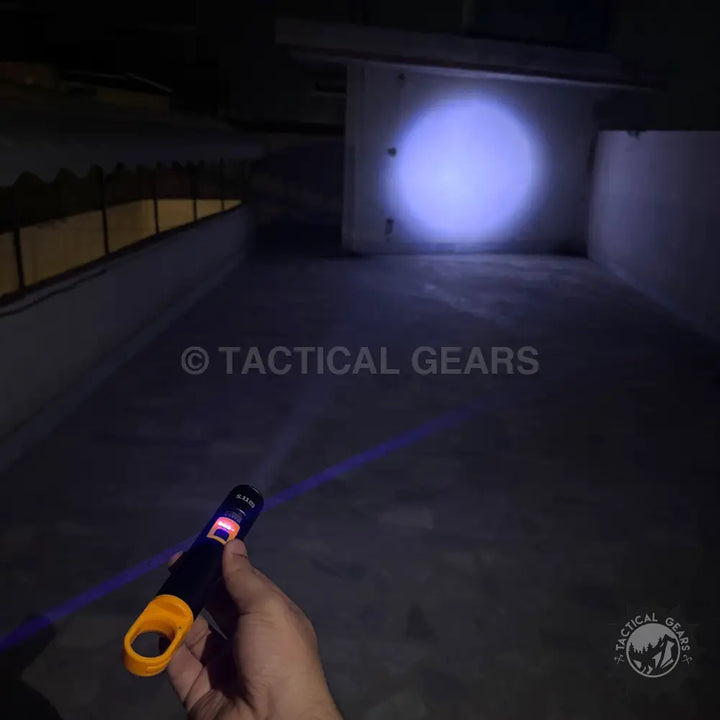 Person holding a Handheld Ultraviolet Camping Flashlight emitting a purple beam for night use