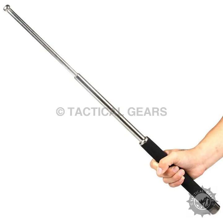 Silver extendable defence tactical tool baton with black grip held in hand