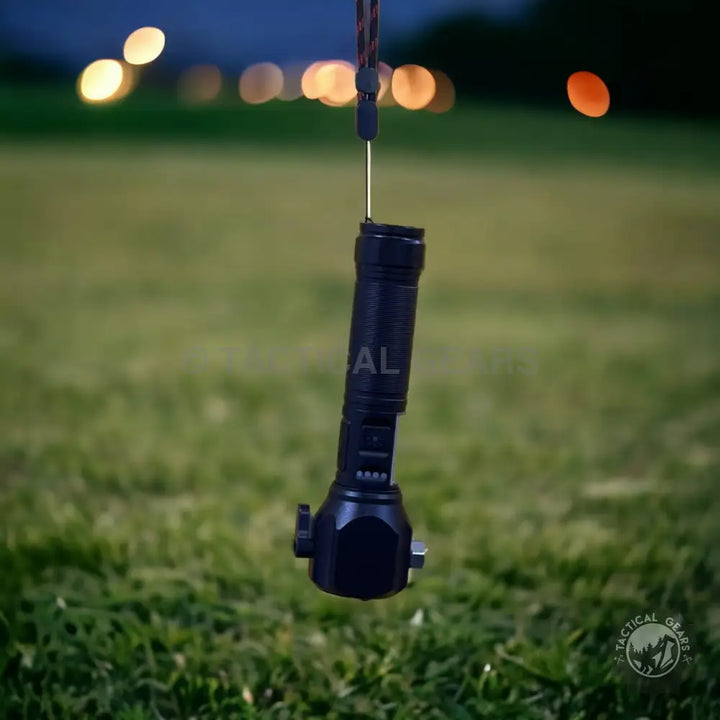 Black tactical flashlight hanging from lanyard for emergency situations and long-distance illumination