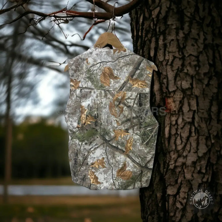 Hunting camouflage outdoor vest hanging from tree branch, part of outdoor jacket collection
