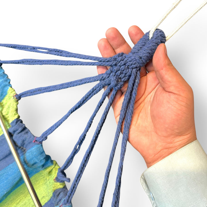 Hand holding a blue rope harness for green striped fabric imported hammock