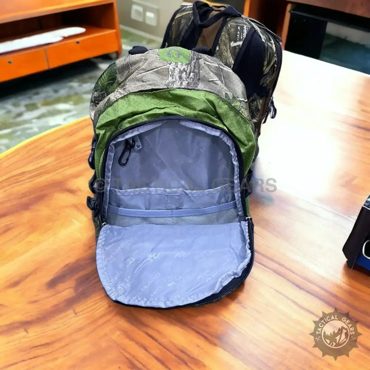Camouflage and green Jungleland backpack open with internal pockets and carabiner clip