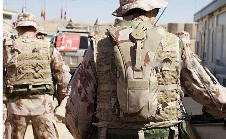 Camouflage hydration pack with shoulder strap on soldier’s back for outdoor hydration