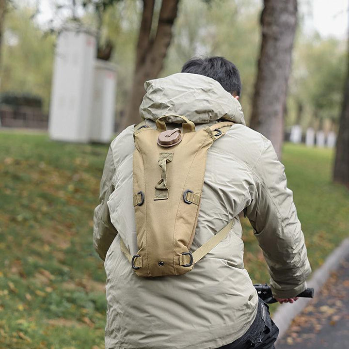 Person cycling outdoors with KMS Water Camel Pack 2.2-Liters hydration pack and shoulder strap