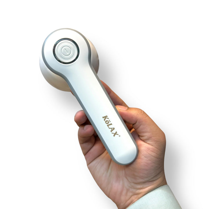 Hand holding a white and grey Kolax lint remover fabric shaver for effective lint removal