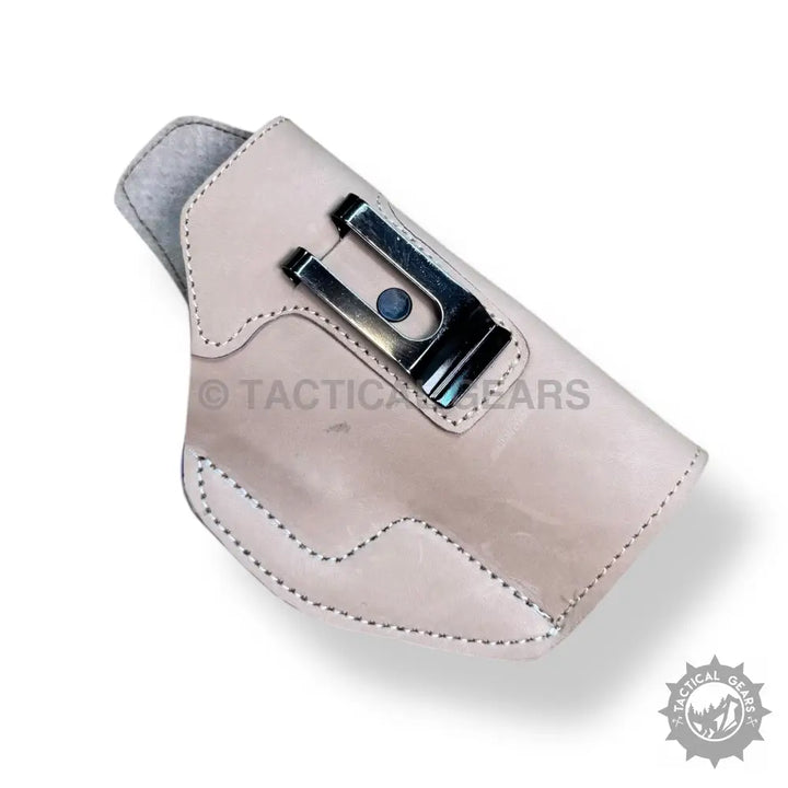 Light-colored leather gun holster with metal belt clip for easy 9MM pistol access